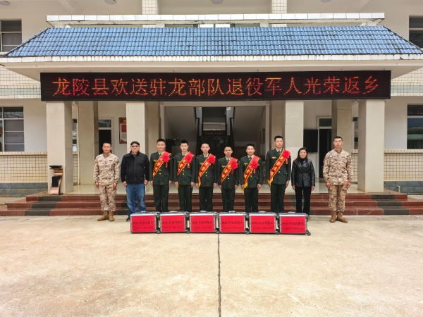 图为龙陵县欢送驻龙部队退役军人返乡，郭玉琴与退役士兵及部队代表合影。